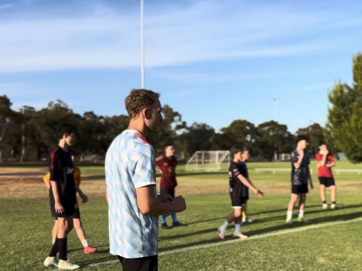 Riley on the pitch with players during a training session